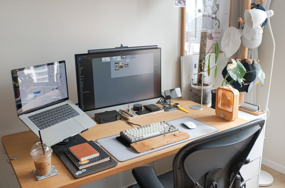 Configuración de oficina elegante con laptop, monitor y accesorios que mejoran la productividad